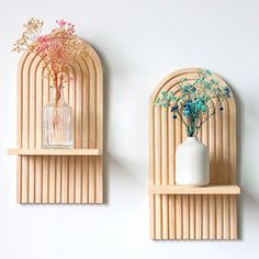 two wooden wall shelves with vases and flowers on them, against a white wall