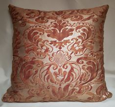 an orange and gold decorative pillow on a white background