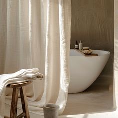 a white bath tub sitting next to a wooden stool