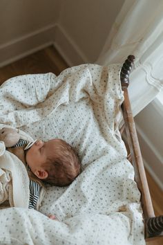 a baby sleeping in a crib with a teddy bear