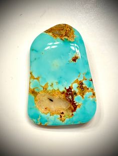 a piece of turquoise and gold colored stone