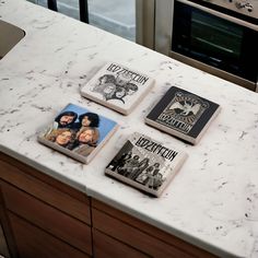 four books sitting on top of a white counter next to an oven and microwave in a kitchen