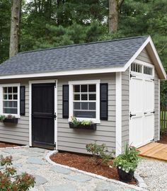 a small shed with black shutters and windows