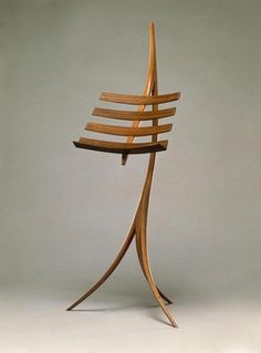 a wooden chair that is sitting in the middle of a floor stand with multiple strips of wood on it