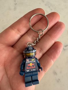 a lego figure keychain that is in someone's hand