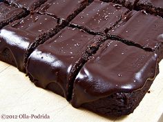 chocolate brownies are cut into squares on a cutting board, ready to be eaten