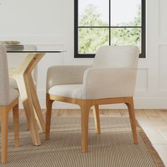 a dining room table with two chairs and a rug