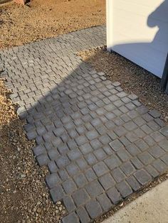 a brick walkway next to a garage door