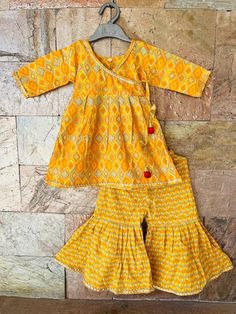 Beads shown on top/ Kurti are not attached for sizes under 3 years. Specifications: *Brand - Ethnic Pehnava *Type - Sharara *Fabric -Cotton *Sleeves - 3/4 th sleeves *Neck - Round *Closure - Pullover / Hooks *Lining - Butter Crepe (Very Soft) *Salwar Length - Full Palazzo / Elastic in waistband *Occasion - Ethnic Wear/Festive wear/Party Wear/Wedding Party *Fit - Regular Items included in Package *1 Kurti, 1 Palazzo Wash Care Instructions: HAND WASH /GENTLE WASH ONLY. Wash dark colors separately. Festive Cotton Designer Wear Sets, Festive Cotton Sets For Designer Wear, Festive Cotton Designer Sets, Cotton Sharara With Bandhani Print For Diwali, Diwali Cotton Sharara With Bandhani Print, Cotton Long Sleeve Palazzo Set With Gota Work, Cotton Palazzo Set With Gota Work And Long Sleeves, Long Sleeve Cotton Palazzo Set With Gota Work, Fitted Cotton Palazzo Set With Gota Work