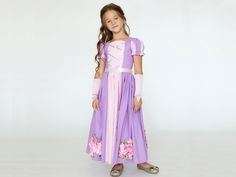 Step into a storybook fantasy with our enchanting Rapunzel girls dress. Crafted with the utmost attention to detail, this purple fairytale princess dress is perfect for any little girl's fantasy-themed occasions. Whether celebrating a birthday as the long-haired princess, attending a ball, or choosing the ideal Halloween costume, our junior Tangled dress crafted from soft cotton and adorned with satin ribbon ensures elegance and comfort. The legend of Princess Rapunzel, a beautiful maiden trappe Fairytale Costume Party Dress With Fitted Bodice, Purple Fantasy Costume Party Dress, Purple Fantasy Dress For Costume Party, Fantasy Style Purple Dress For Costume Party, Princess Dress For Costume Party With Fitted Bodice, Princess Dress With Fitted Bodice For Costume Party, Princess Style Dress For Costume Party With Fitted Bodice, Fairytale Dress For Halloween, Fairytale Halloween Fancy Dress