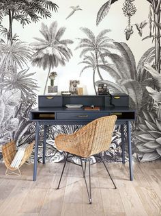 a desk with two chairs in front of a wallpapered jungle scene on the wall