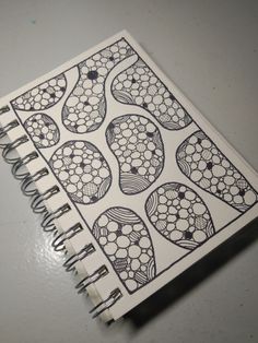 an open spiral notebook with black and white designs