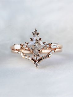 an engagement ring with two pear shaped diamonds on the side and three baguettes in the middle