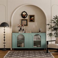 a living room with a blue cabinet and two chairs next to a potted plant