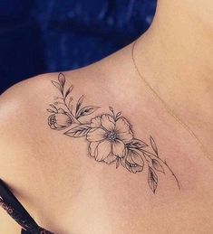 the back of a woman's shoulder with flowers and leaves on her left side