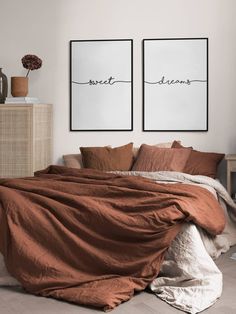 two framed pictures above a bed in a room with brown linens and pillows on it