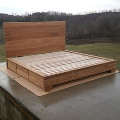 a bed that is sitting on top of a concrete slab in the middle of a field