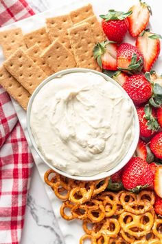 strawberries, pretzels and crackers on a white plate with cream cheese