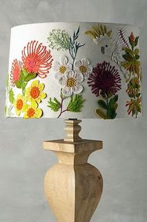 a lamp that is on top of a wooden base and has flowers painted on it