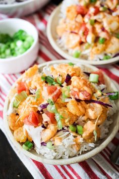 two bowls filled with rice and vegetables on top of a red and white table cloth