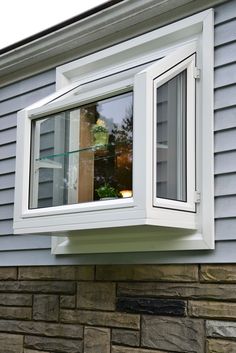 a white window sitting on the side of a house