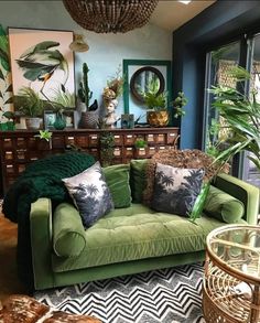 a living room filled with lots of green furniture and plants on top of the couch