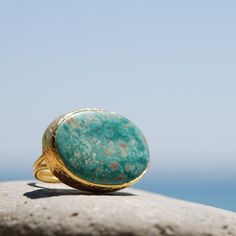 This Ring is handcrafted with pure and sterling silver. The gold color is done by coating silver with 18karat gold. This ring is designed with an Oval Turquoise Stone.Size: The ring will be prepared adjustable so that you can change its size one size up and down. Please tell me your ring size during checkout and I will arrange it accordingly.Each stone has its own texture and color which differ slightly from one another. Your earrings will be one of a kind for I will be preparing a new one for y Unique Gold Turquoise Ring With Gemstone, Handmade Gold Turquoise Ring, Unique Handmade Gold Turquoise Ring, Elegant Handmade Gold Turquoise Ring, Artisan Gold Turquoise Ring, Bohemian Gold Rings With Large Stone, Handmade Bohemian Gold Turquoise Ring, Handmade Gold Bohemian Turquoise Ring, Luxury Gold Turquoise Ring