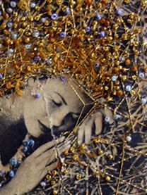 a woman with her eyes closed is surrounded by gold and blue bead garlands