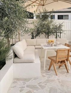 an outdoor seating area with table, chairs and umbrella