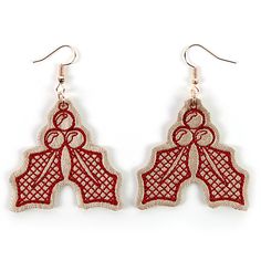 two pairs of earrings with red threadwork on the bottom and one pair is hanging from hooks