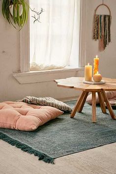 a living room filled with furniture next to a table and a potted plant on top of a window sill