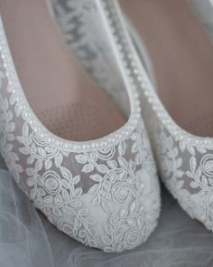 wedding shoes with white lace and pearls on them