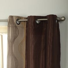 two curtains hanging on the side of a window sill in front of a curtain rod