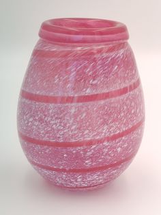 a pink vase sitting on top of a white table