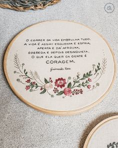 two embroidery hoops with words on them sitting on the floor next to each other