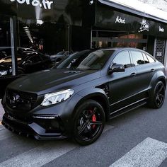 a black mercedes suv parked in front of a building