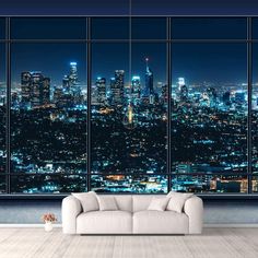 a living room with a couch and large window overlooking the city lights at night time