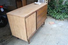 a wooden dresser sitting next to a motorcycle