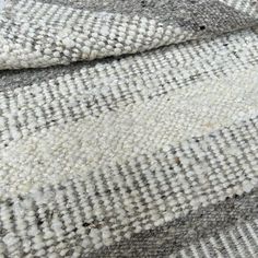 a close up view of the texture of a rug with grey and white stripes on it