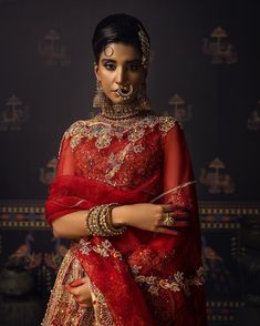 Indian Red Bridal Lehenga with Choli and Dupatta Dress is an epitome of tradition and royalty that gives the gorgeous bride a magnificent royal look at the wedding. Kora dabka, stonework, and Kundan details give a charming touch to this beautiful Lehenga Choli. Bridal Choli The sleeveless choli is gracefully emblazoned with luxury designs and dabka work. Kundan, floral designs, and shimmering adornments enhance the charm of the choli. Goldwork and a stylish back give a chic look to this bridal c Red Sets With Tilla In Traditional Drape, Red Sets With Tilla Detail And Traditional Drape, Festive Red Sharara With Tilla Details, Festive Red Sharara With Tilla, Red Saree Gown With Dupatta, Red Tilla Saree For Reception, Red Traditional Wear With Sheer Dupatta And Kundan, Red Anarkali Gown For Traditional Ceremonies, Red Tilla Choli For Wedding