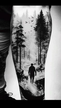 a black and white photo of a man walking through the woods with birds flying overhead