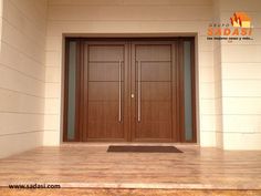 an empty room with two wooden doors on the wall and wood flooring in front of it