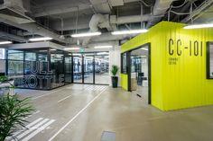 the inside of an office building with bright yellow walls and black doors that read c c - 101