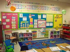 a classroom with lots of desks, chairs and bulletin boards on the back wall