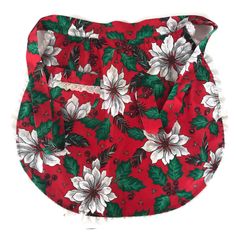 a red purse with white poinsettias and green leaves on the front, sitting against a white background