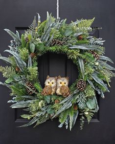 two owls sitting on top of a wreath