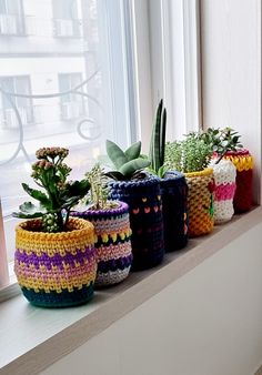 a row of crocheted planters sitting on top of a window sill