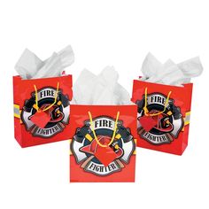 three red fire department bags with white tissue paper on them, each containing a firefighter's emblem