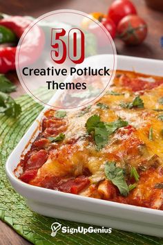 a casserole dish with tomatoes, cheese and herbs in it on a green place mat