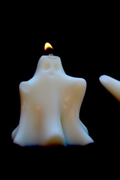 two white candles sitting next to each other